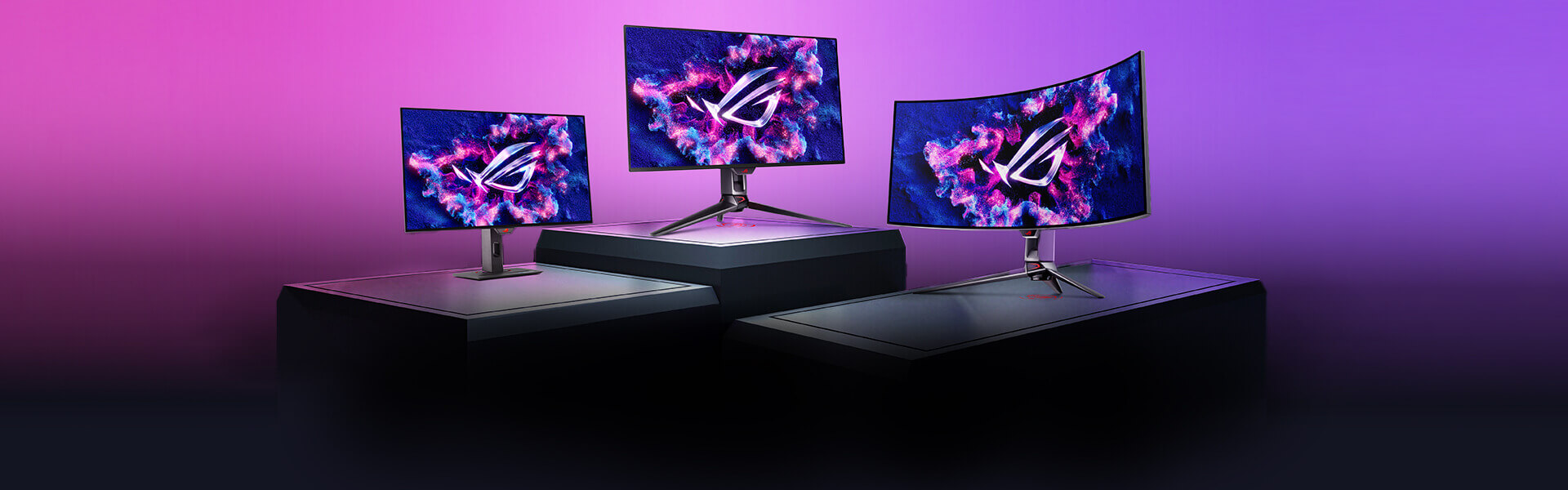 三台 ROG 显示器矗立在色彩斑斓的背景墙前。