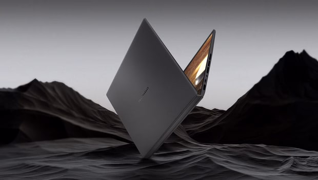 图片显示一台莫赫灰配色的 ASUS 笔记本电脑，倾斜放置在类似悬崖的纹理深色表面上。