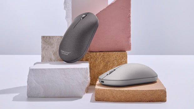 一个 ZenMouse 鼠标放在笔记本电脑旁边。