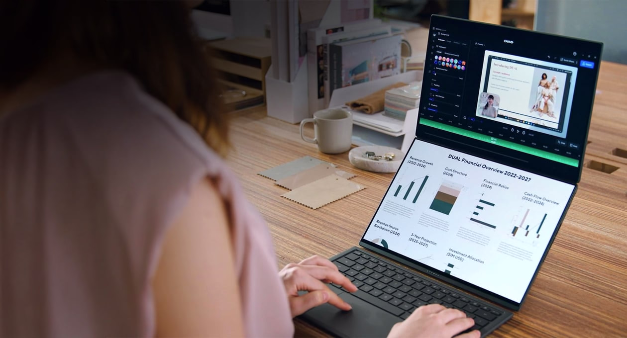 图片显示一台用于生产力工作的 ASUS Zenbook DUO。上方屏幕显示图表，下方屏幕显示其他数据面板。