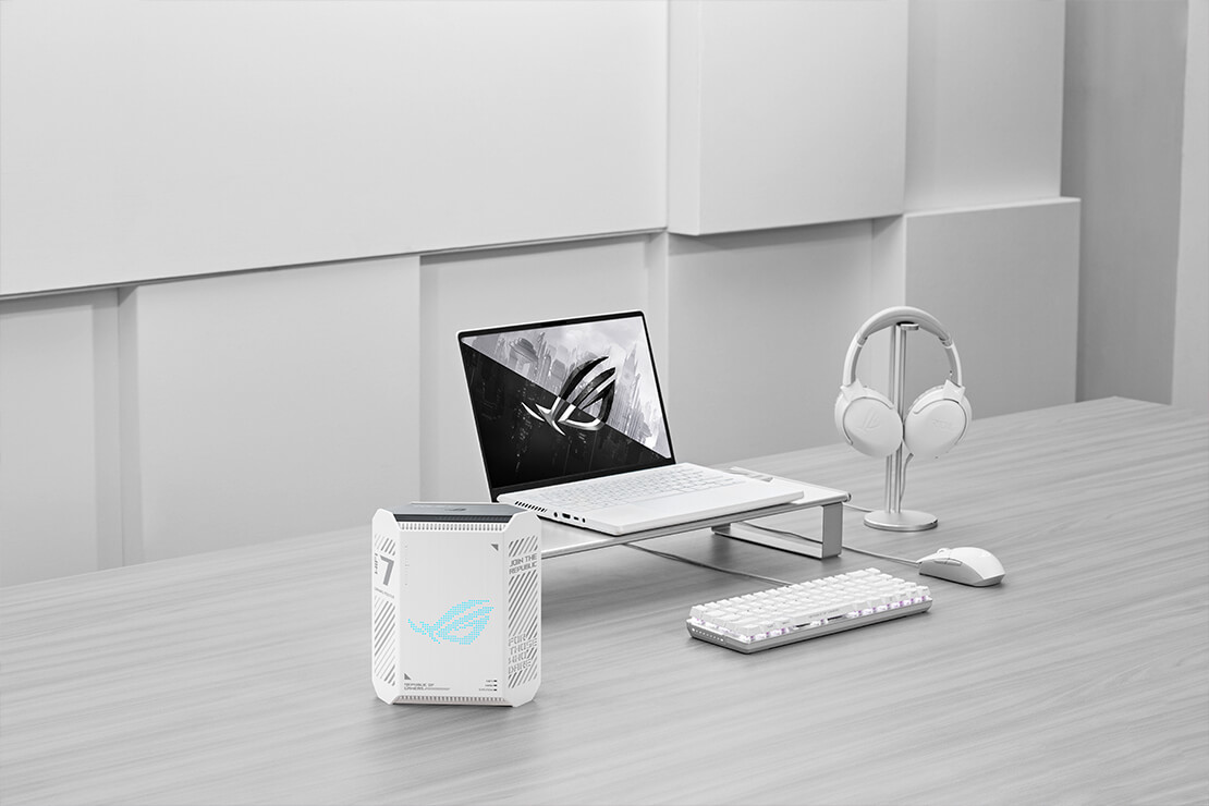 极简主义工作空间配置:白色ROG笔记本电脑、无线耳机、键盘和鼠标,ROG 魔盒 Air WiFi 7路由器置于桌面左侧。