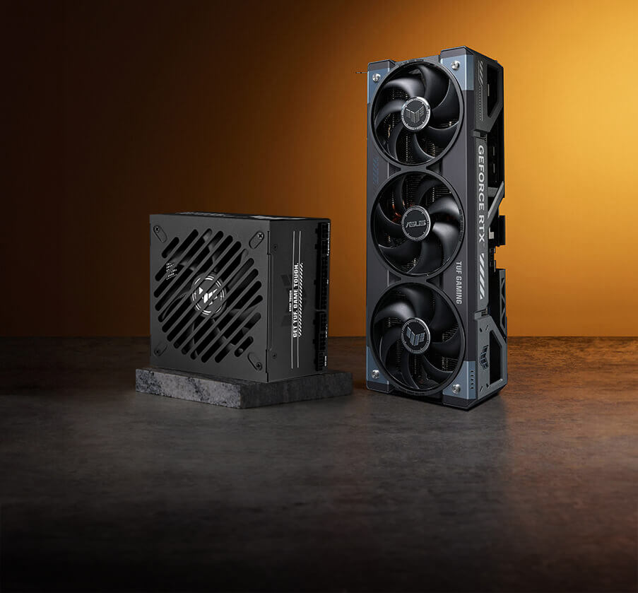 一款 TUF GAMING Gold EVO 电源和一张 TUF GAMING 显卡放置在橙色背景的石质表面上。