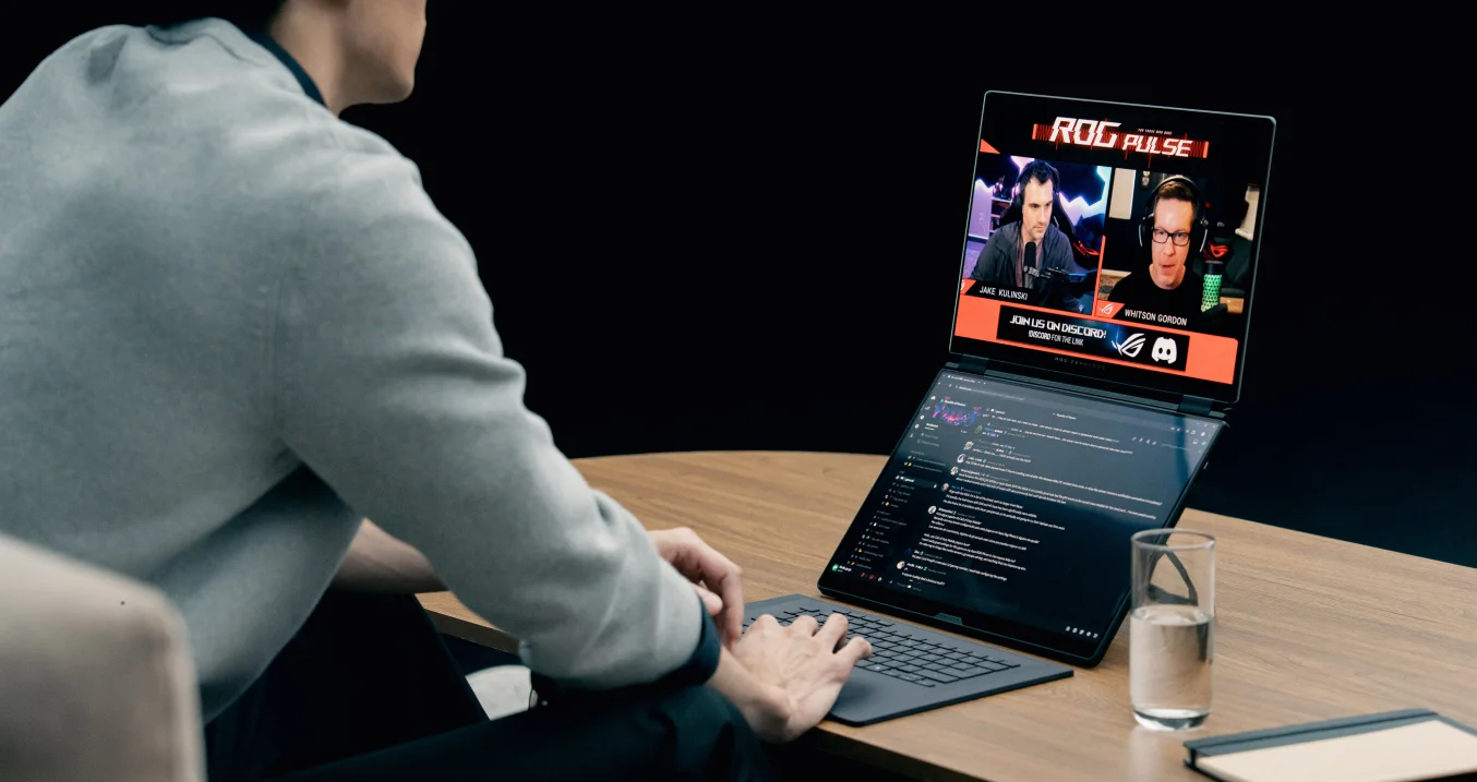 A man using 幻16 双屏with the dual screen mode watching streaming and chatting in discord.