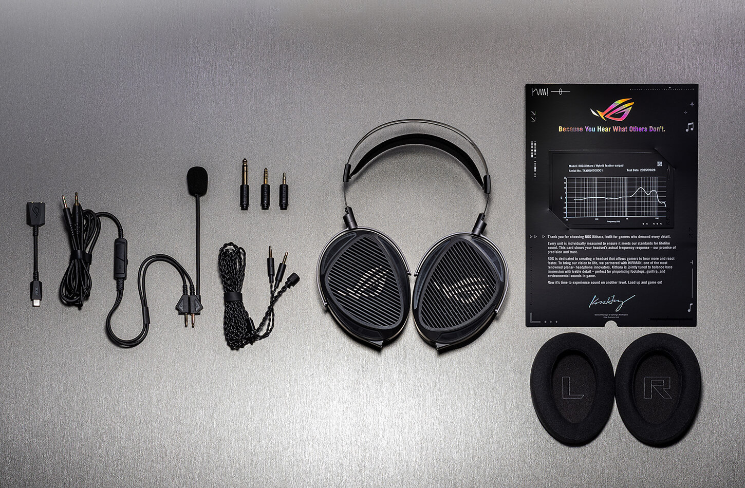 ROG臻世gaming headset and included accessories laid out, including cables, swappable plugs, boom microphone, ear pads, and sound signature certificate