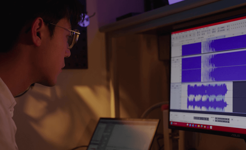 Person monitoring audio waveforms on a computer screen to ensure each driver is measured, sorted, and paired for consistent frequency response between earcups.