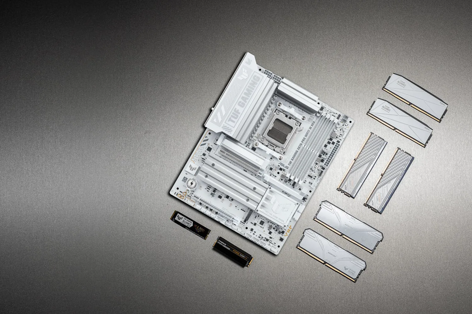 TUF GAMING X870-PRO WIFI7 W NEO 主板置于金属表面之上，周围整齐陈列着包括 M.2 固态硬盘和内存模块在内的各种兼容 PC 组件，象征着 TUF 游戏联盟所保证的可靠装机兼容性。