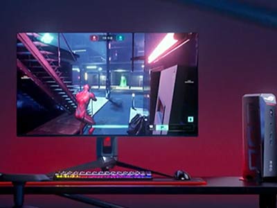 ROG NUC 16 放在一台正在玩游戏的显示器旁边。