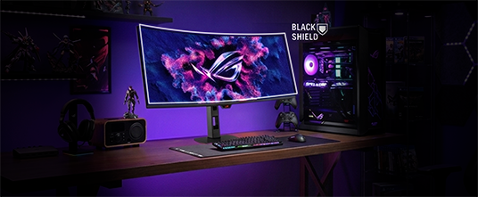 ROG XG34WCDMS 曲面电竞显示器，屏幕上亮起 ROG Logo。图中展示了包含耳机、键盘、鼠标和电脑主机的全套桌面场景。右侧显示的 BlackShield 图标，示意该面板拥有更高的硬度与更佳的抗刮擦性能。