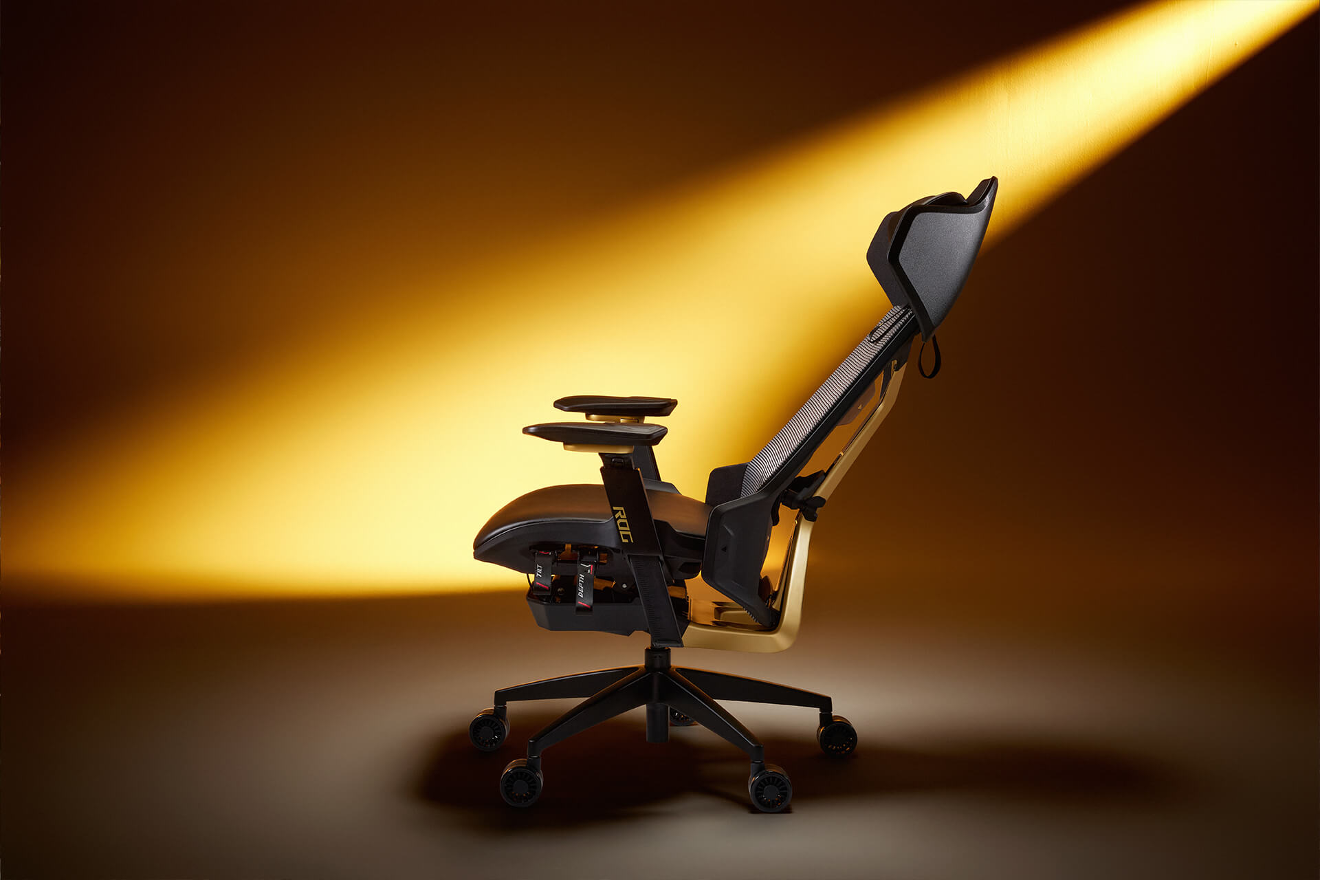 Side view of the fully reclined ROG Destrier Edition 20 gaming chair, illuminated by ambient gold lighting