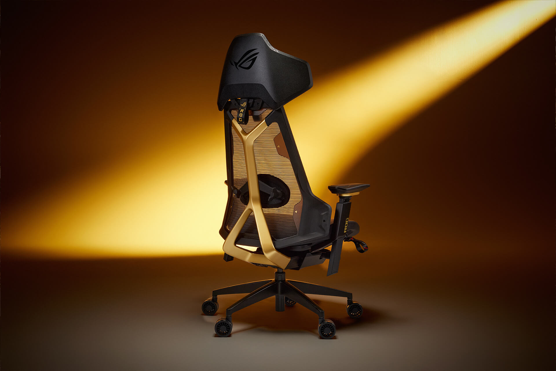 Rear view of the ROG Destrier Edition 20 gaming chair, illuminated by ambient gold lighting
