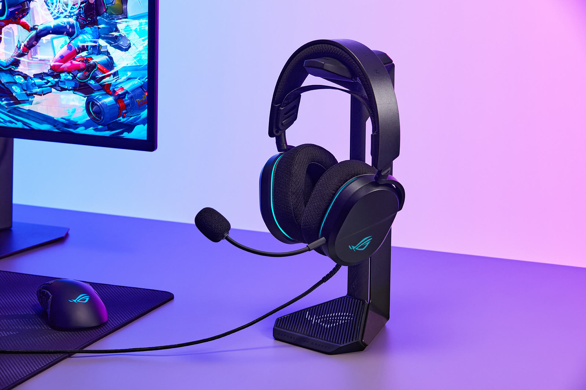 ROG 破风 标准版gaming headset on the ROG Throne II headset stand beside a gaming monitor.