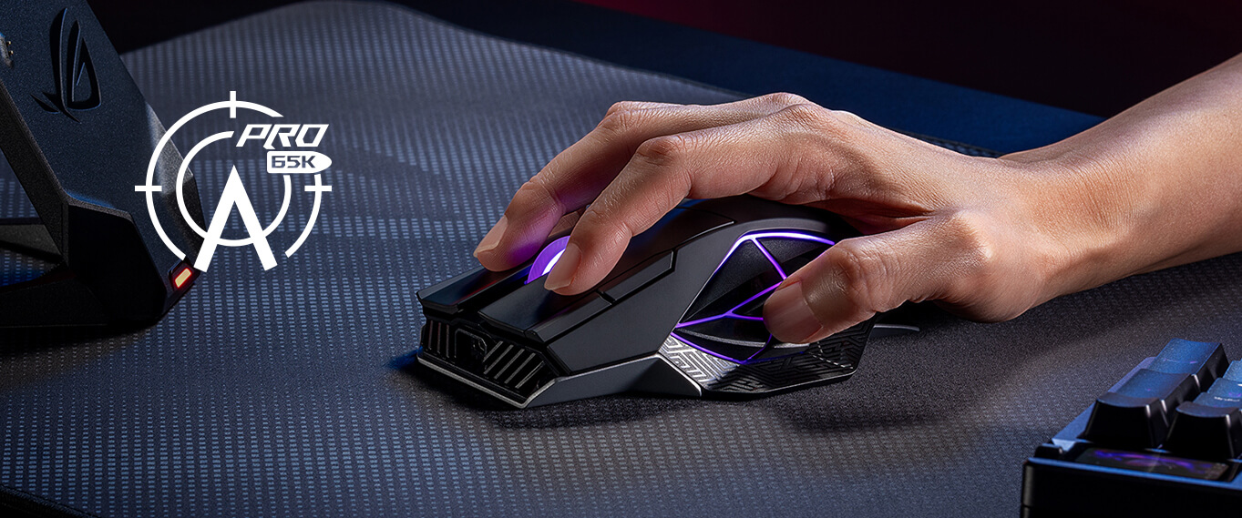 手持 ROG 斯巴达 X 65K 电竞鼠标及身旁的 AimPoint Pro 65K 传感器