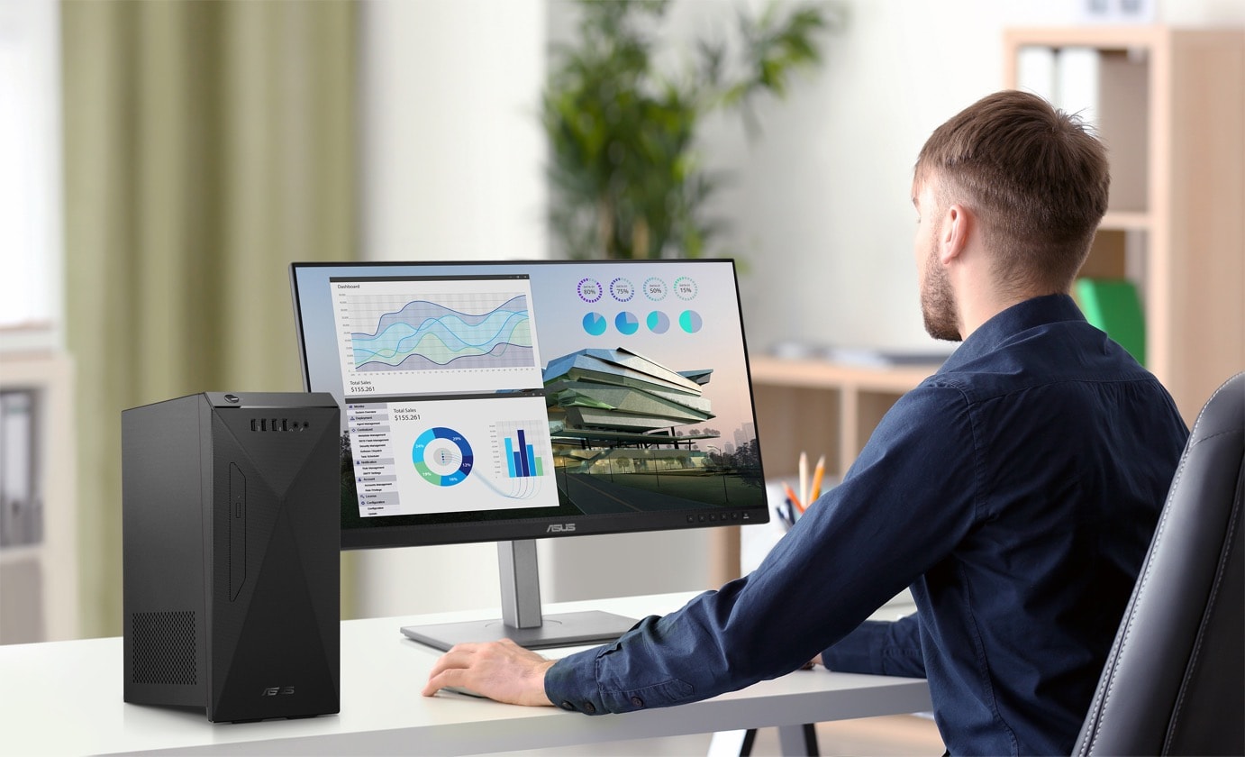 A man is analyzing data through looking at the monitor that is power by an ASUS S501ME on his left-hand side. 