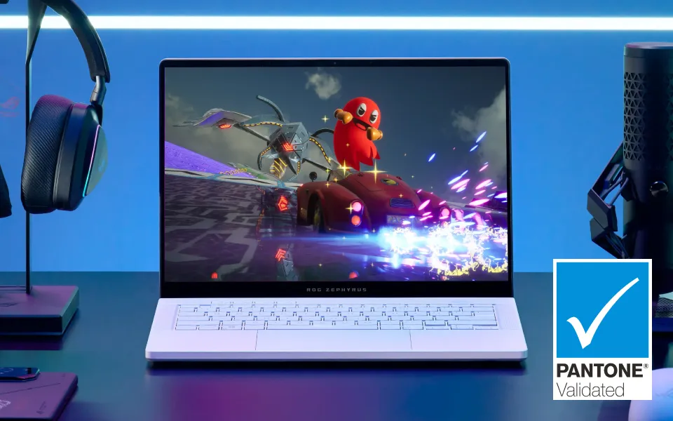 A white ROG laptop on a desk with a mic and headset, and a racing game on screen. 