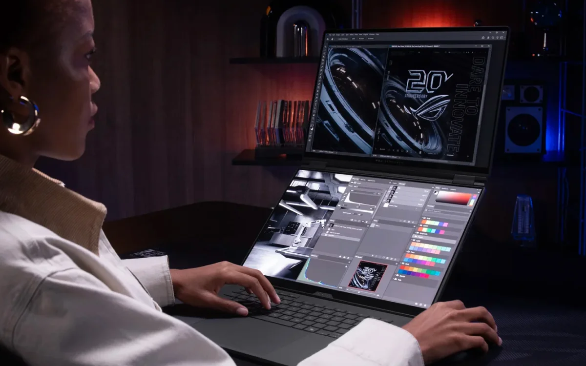A person working on productivity tasks with the ROG Zephyrus Duo, with both screens visible and the wireless keyboard on the desk.