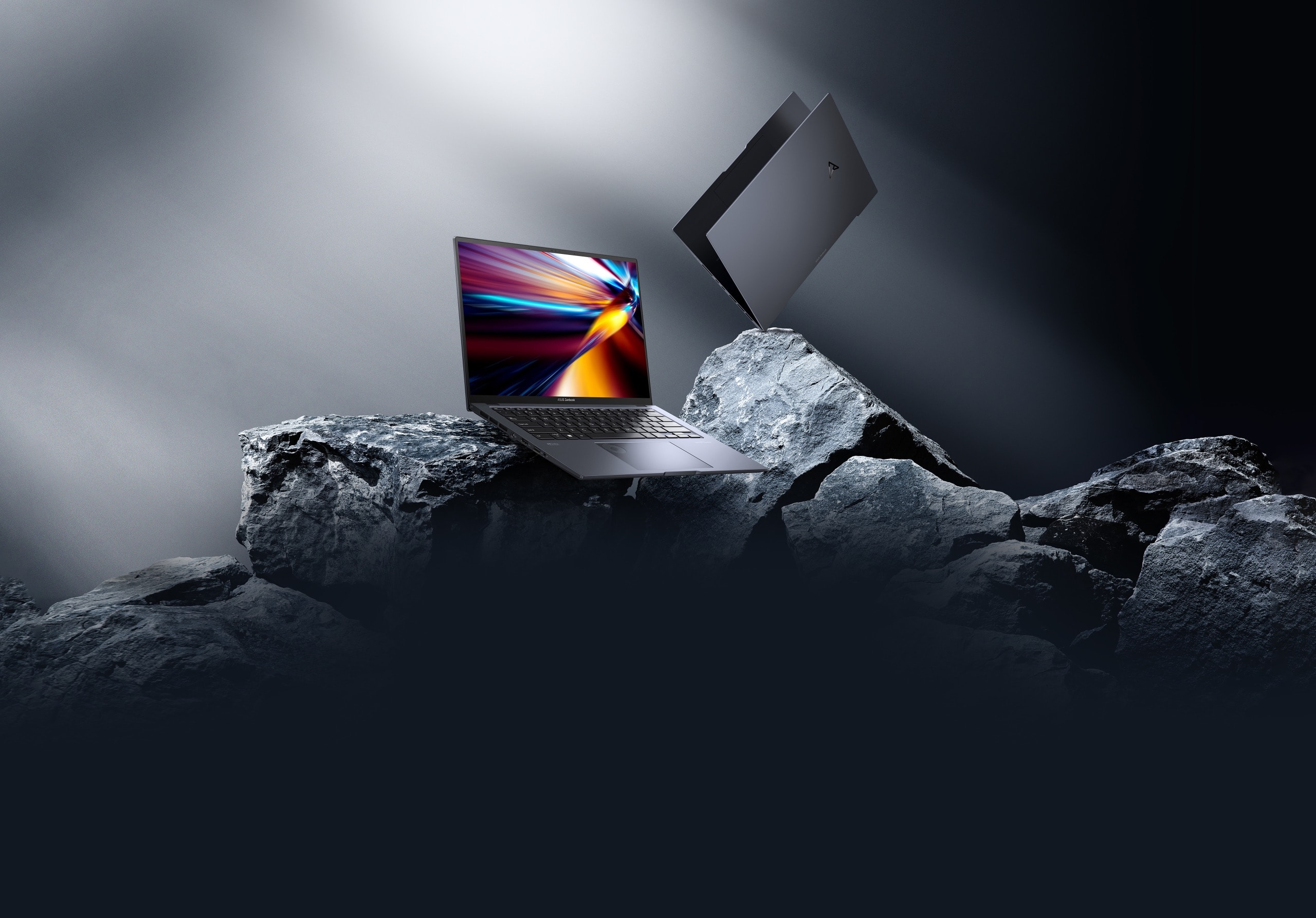 Zenbook Pro 14 Duo OLED 开启 45 度，斜置于黑色岩石