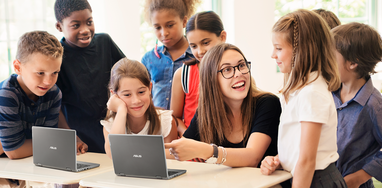一位老师和幼儿园到高中的学生在教室里使用 ASUS BR1100 笔记本电脑。