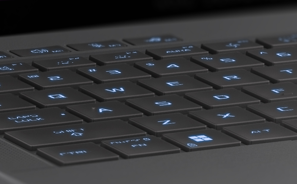 Extreme close up of the WASD keys on the Eclipse Grey Zephyrus G14, with the keys illuminated in blue.