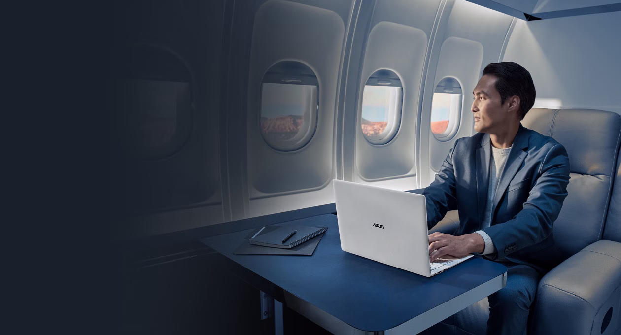 一位商务人士在飞行途中使用 ASUS ExpertBook Ultra 工作。