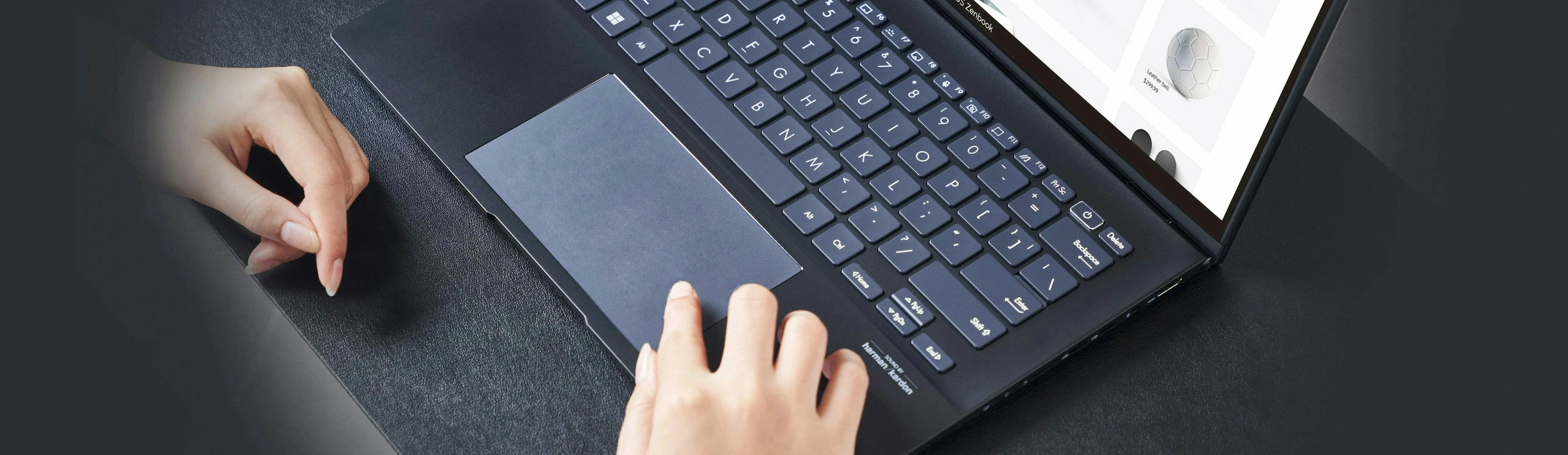 双手在搭载 ErgoSense 键盘的笔电上打字的俯视图。