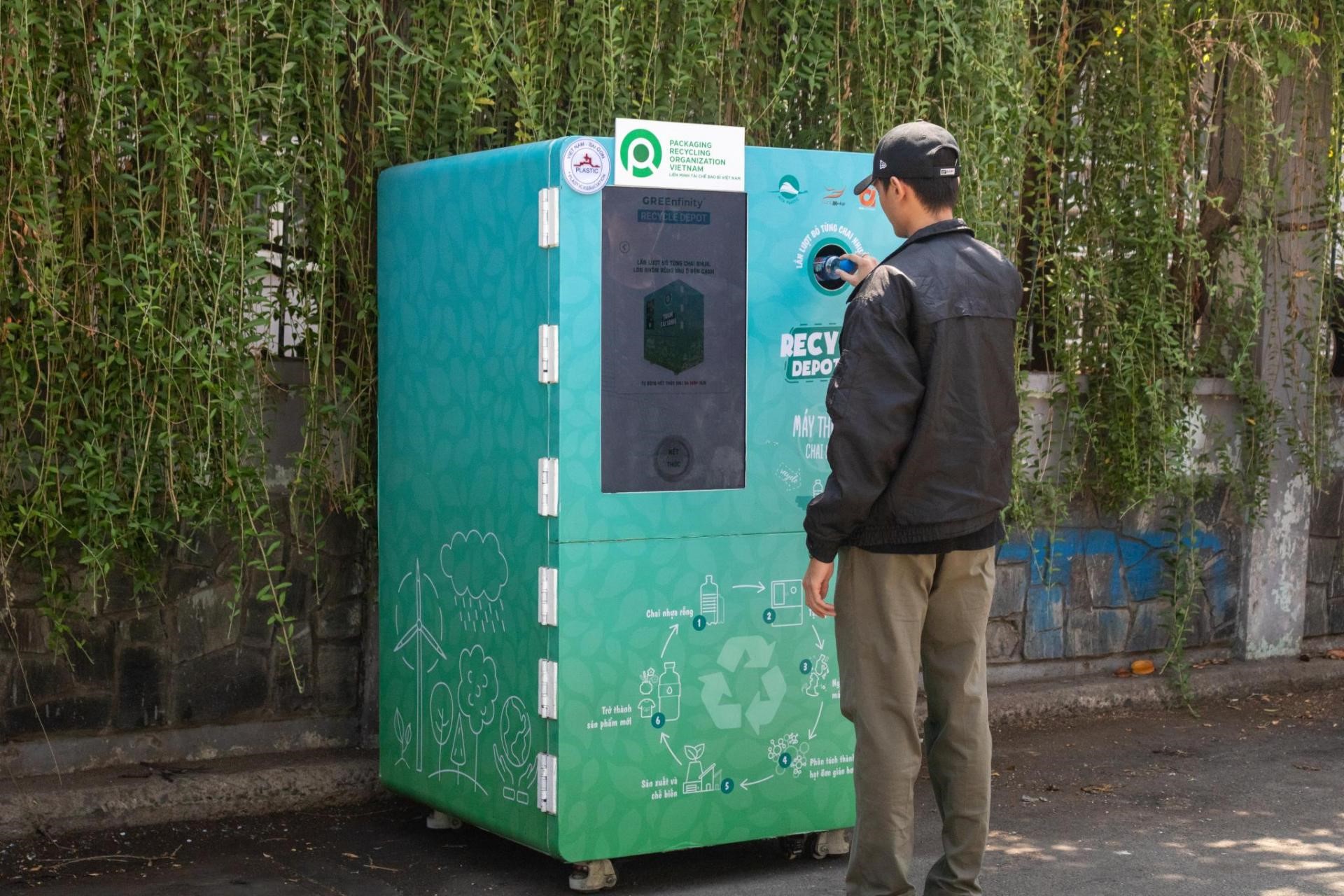A man with hat on standing in front of Alta Media’s Recycling vending machine