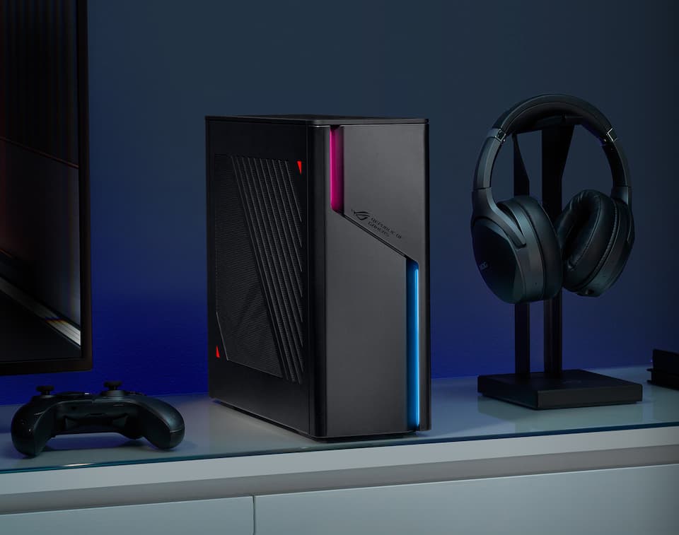 一张冰刃X的照片，显示冰刃X放在显示器旁边的桌子上，一个男人在玩游戏时面带微笑。