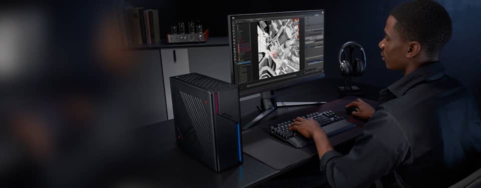 一张冰刃X的照片，显示冰刃X放在显示器旁边的桌子上，有一个人在键盘上打字。