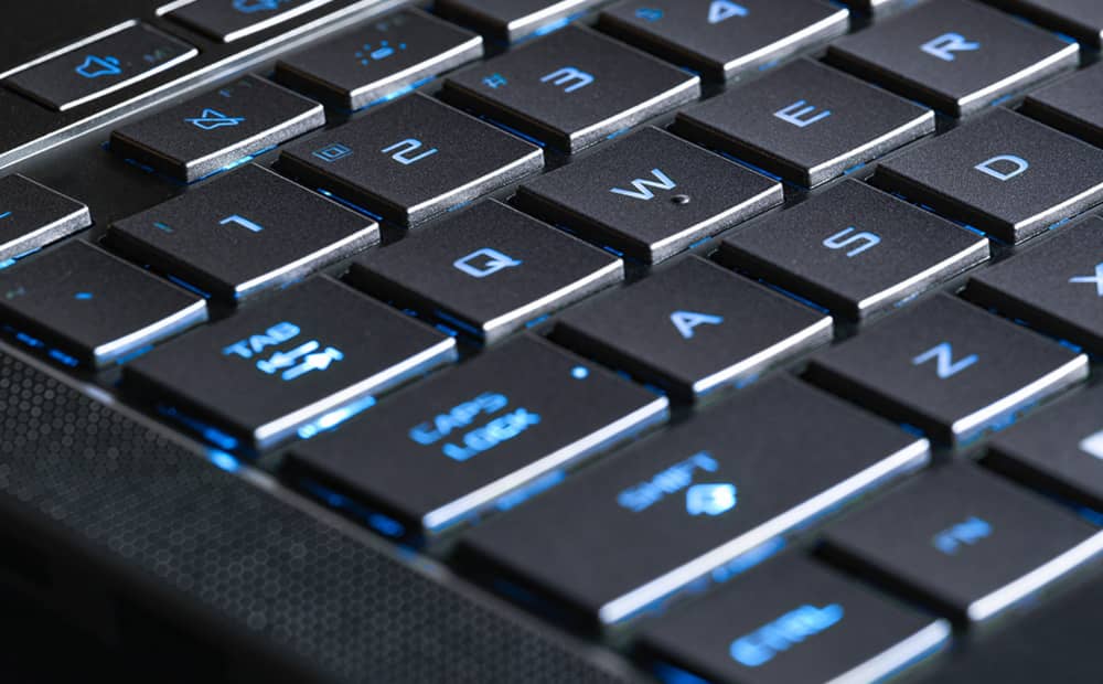 日蚀灰 幻14 Air 电竞笔记本电脑上 WASD 键特写，键盘以蓝光照亮。