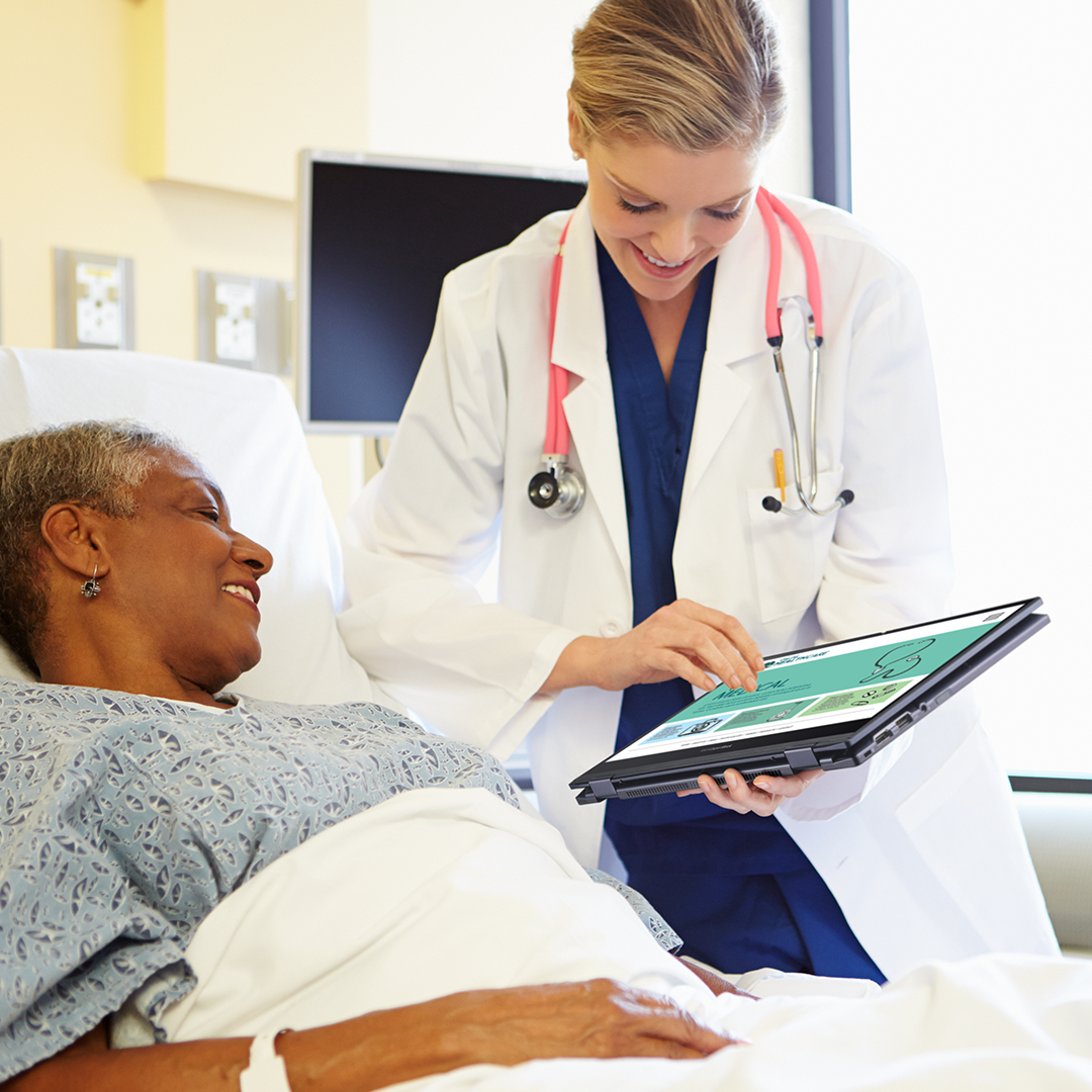 医生使用以平板计算机模式的 ASUS ExpertBook 面带微笑地向躺在病床上的患者展示信息。