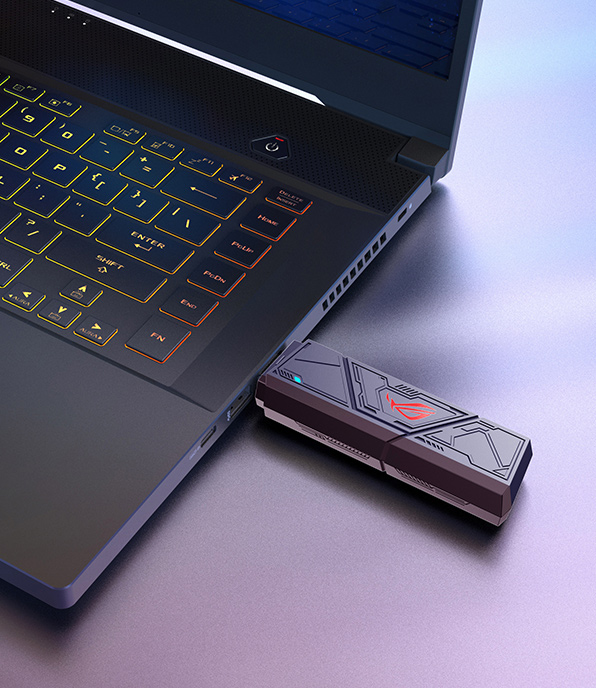 将 ROG 魔钥插入其中一个 USB Type-A 接口的笔记本电脑特写镜头。