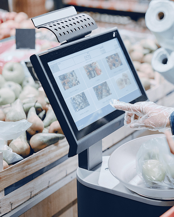 在超市里，一位顾客正在触摸 POS 系统