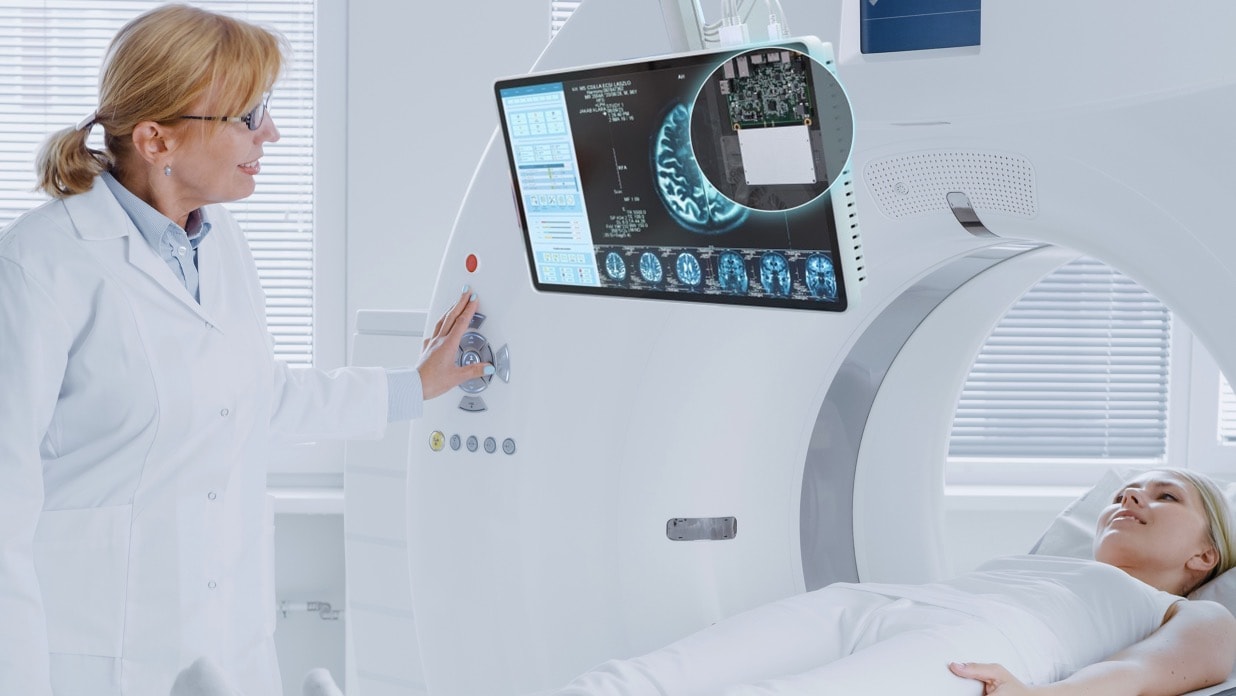 A female doctor uses the medical display screen with built-in  Nuc Pro 13 compute element to explain to the patient lying in CT.