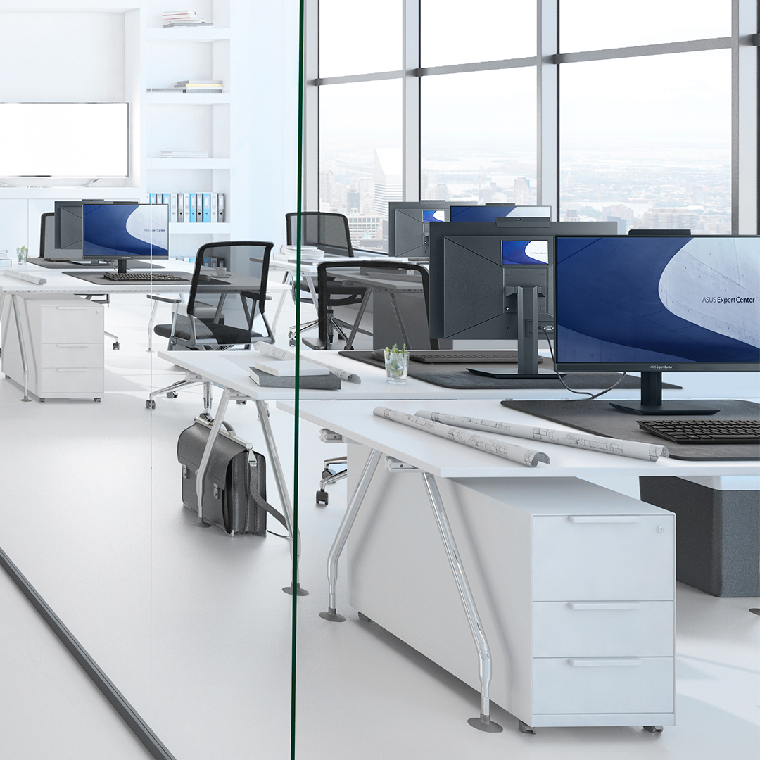 一间大型、干净且现代化的办公室，每个桌上都放着 ASUS ExpertCenter AiO 计算机。