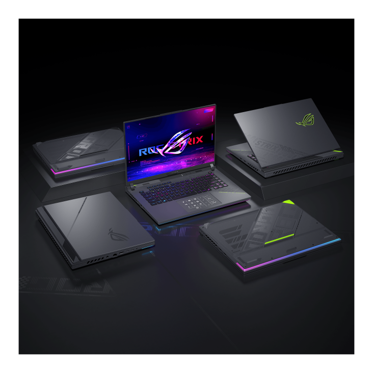 Image of multiple ASUS ROG laptops arranged in a circle with one open in the center displaying the ROG logo on the screen. The laptops feature sleek designs with RGB lighting accents
