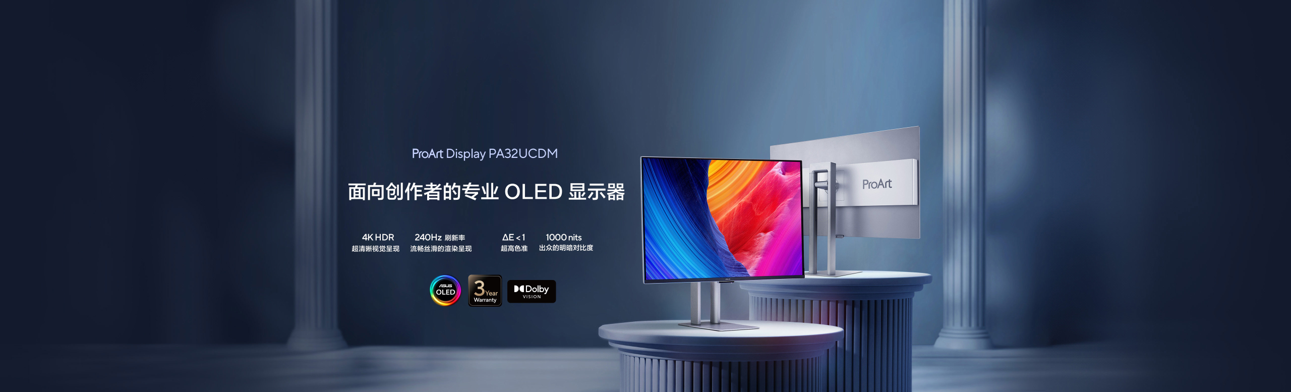 Two sleek ProArt OLED monitors displayed on elegant round pedestals with colorful abstract graphics. Background features grand columns, creating a professional and artistic ambiance.
